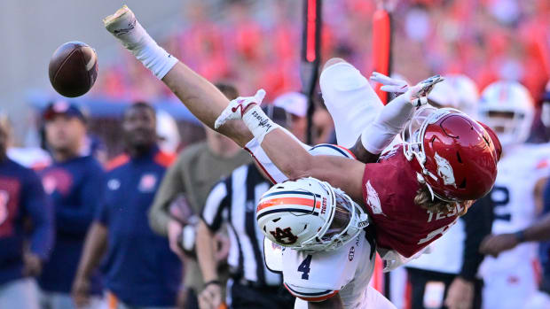 Razorbacks wide receiver Isaac TeSlaa gets pass jarred loose by Auburn's DJ James